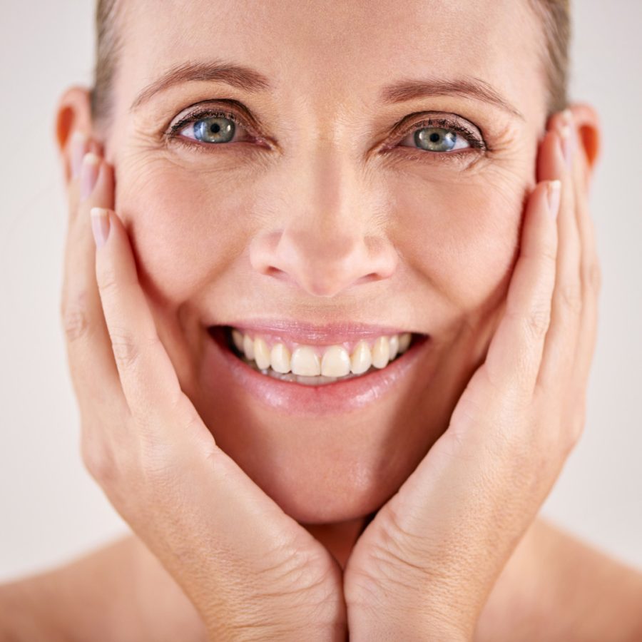 Portrait, smile and senior woman skincare or wellness for face or beauty or isolated and on grey background. Makeup, mature lady and wrinkles or happy model or dermatology and facial aging process.